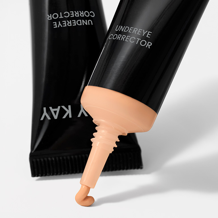 Corrector de ojeras Mary Kay en tono Light Peach con el producto saliendo del envase